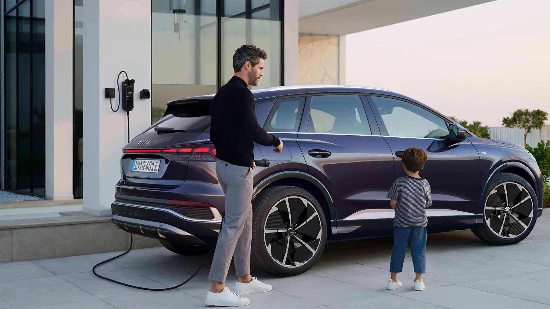 Q4 e-tron plugged in and charging in front of a house
