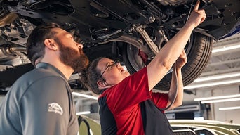 Service technicians repairing vehicle.