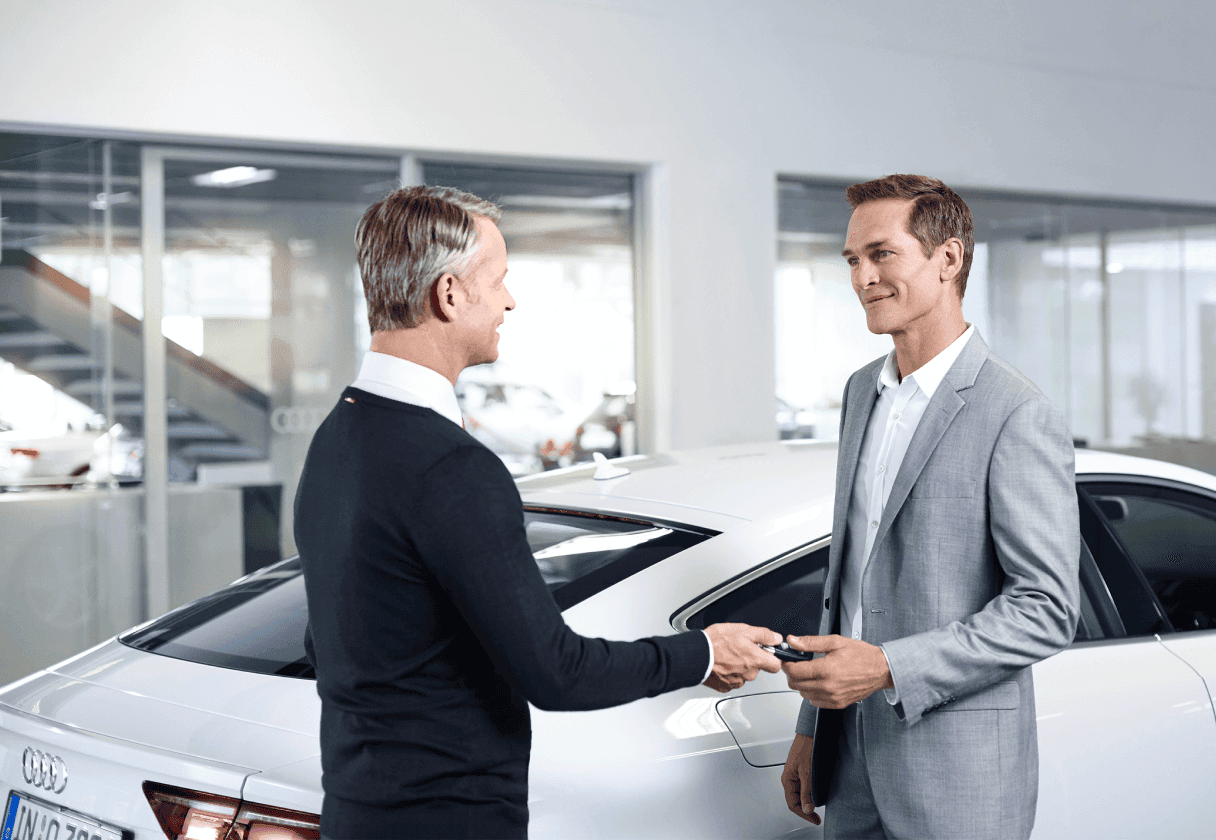 Man receiving the keys to his brand new Audi vehicle.