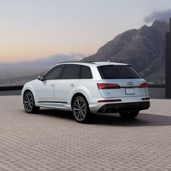 Three-quarter rear view of a white Audi Q7 parked.