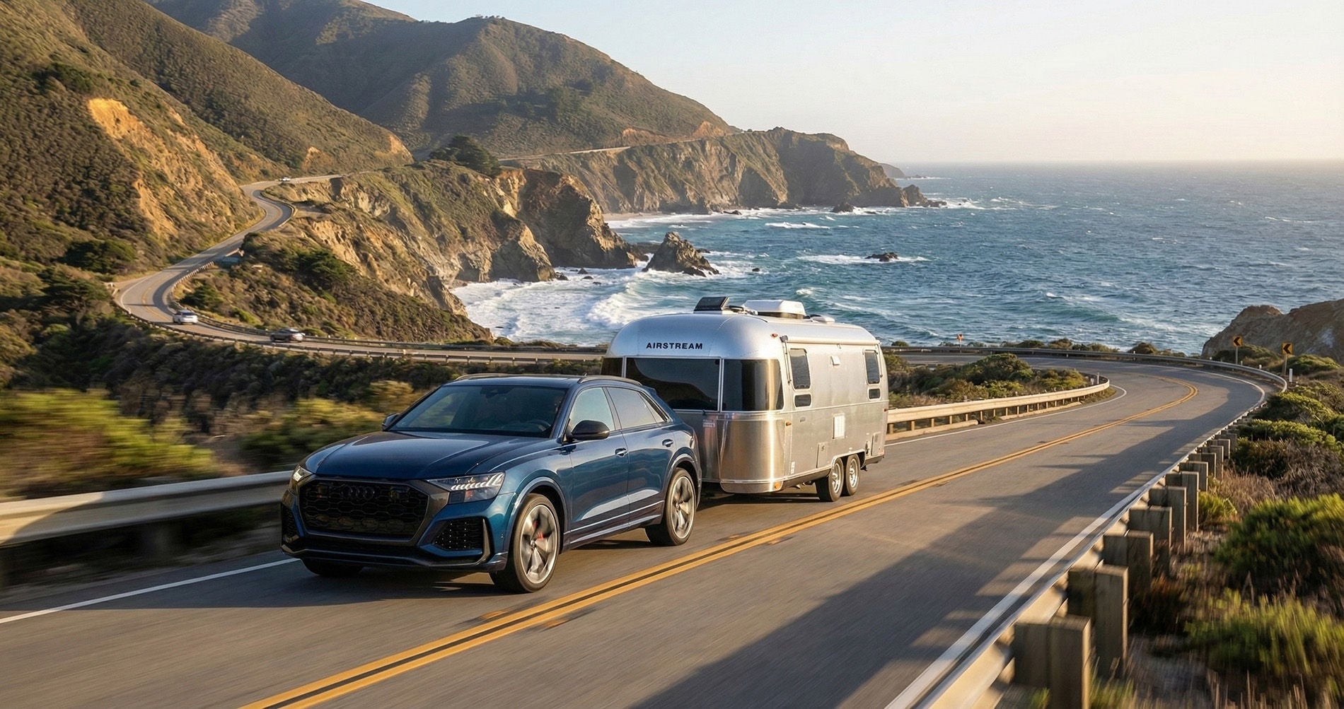 2026 Audi Q8 towing an Airstream camper along the Pacific Coast Highway next to the ocean