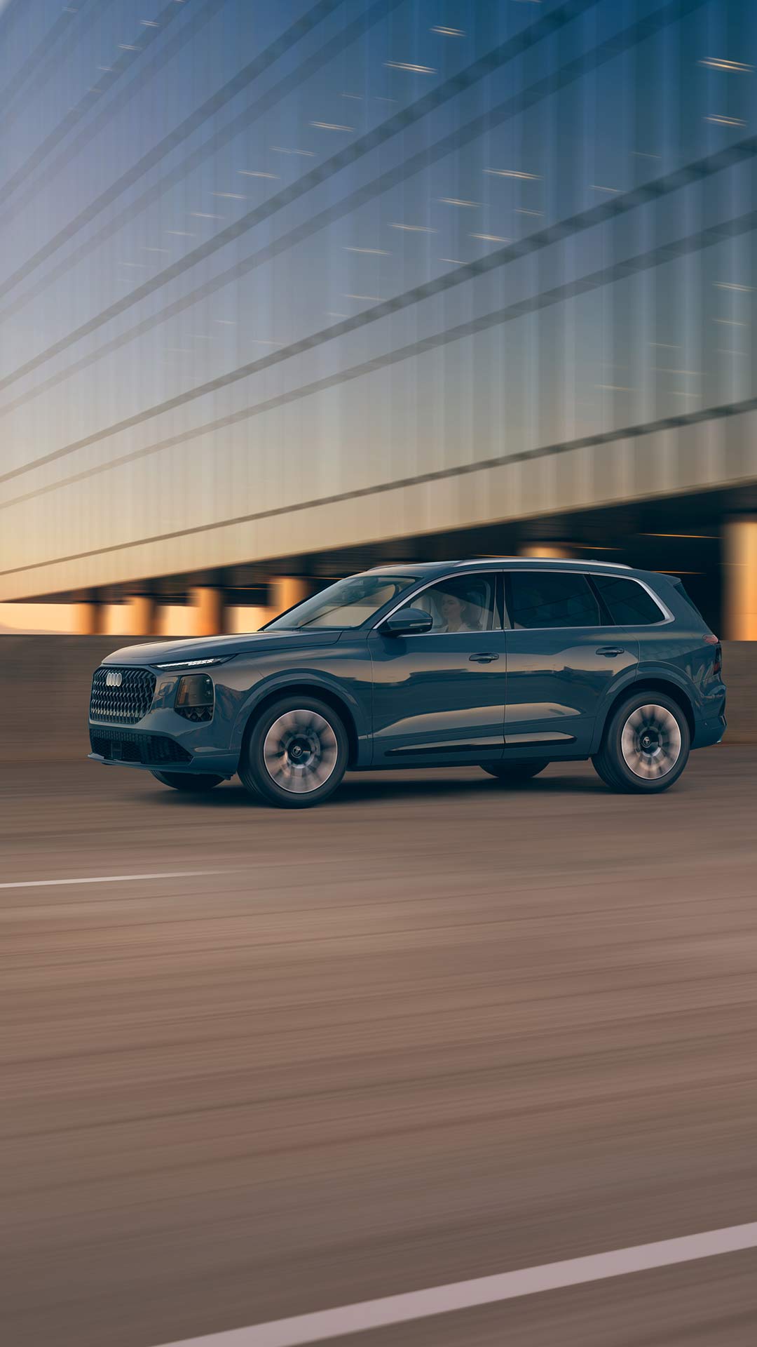 Side view of an Audi Q3 accelerating on highway.