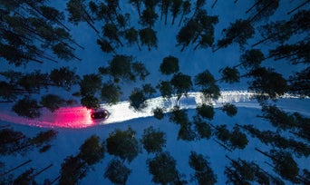 Top down view of an Audi RS e-tron GT driving at night, with red illumination behind it and white in front.