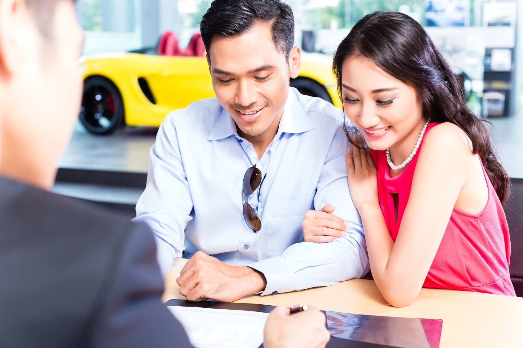 Man and woman at Dealership looking at finance terms