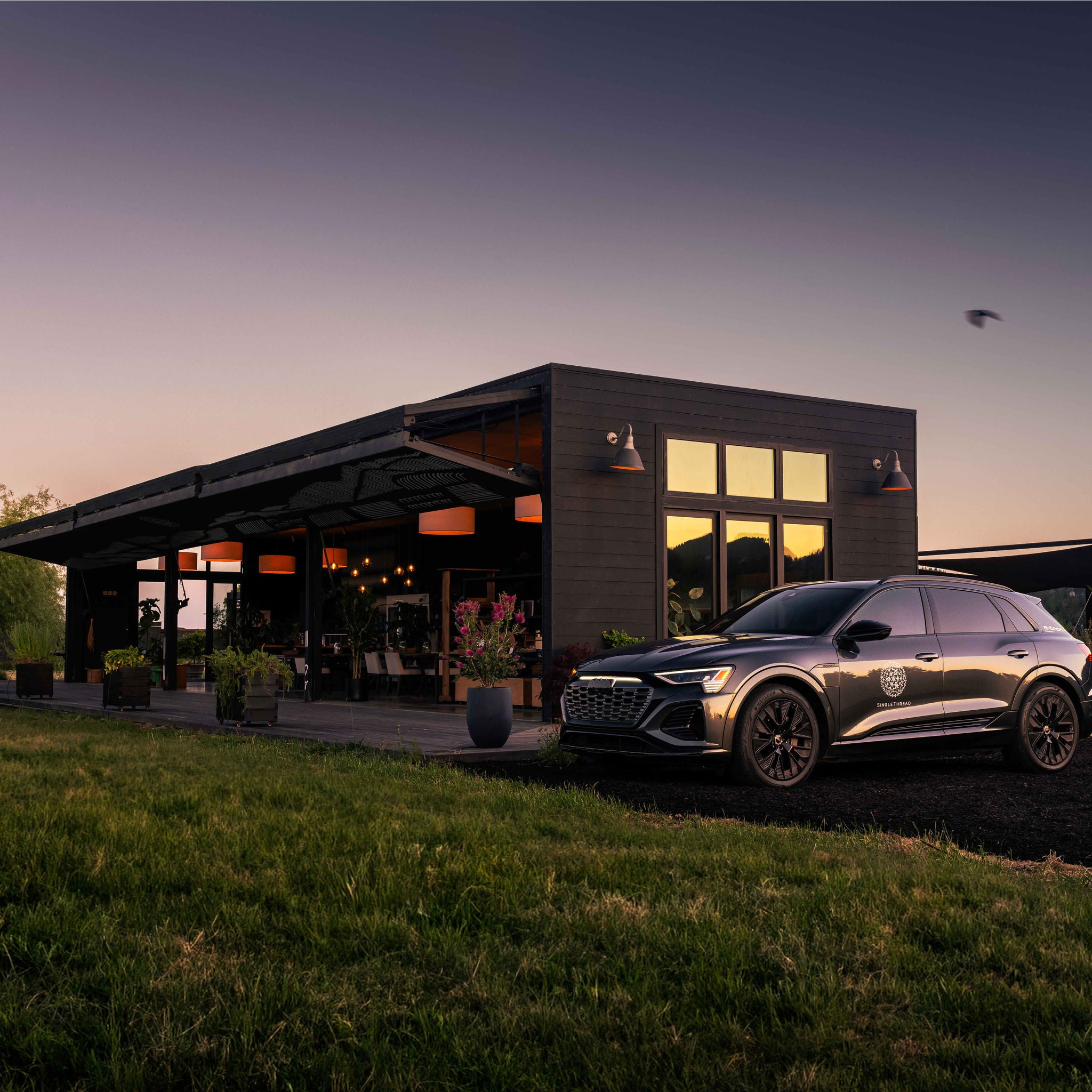 Exterior view of the SingleThread Farm Restaurant Inn with an Audi vehicle parked nearby.