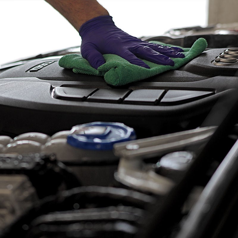 image of a detailers hand wiping down the engine compartment