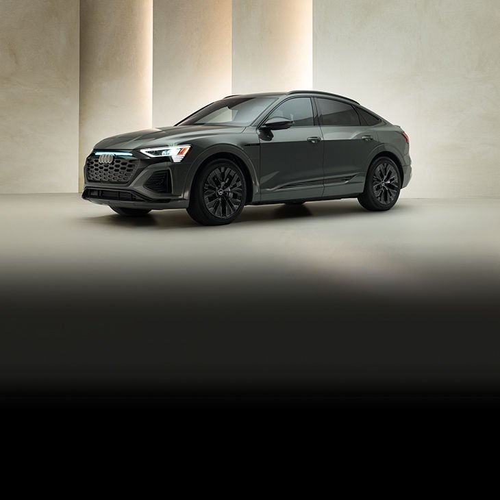 Three-quarter front view of a dark grey Audi Q8 e-tron. 