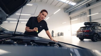 Service technician servicing vehicle.