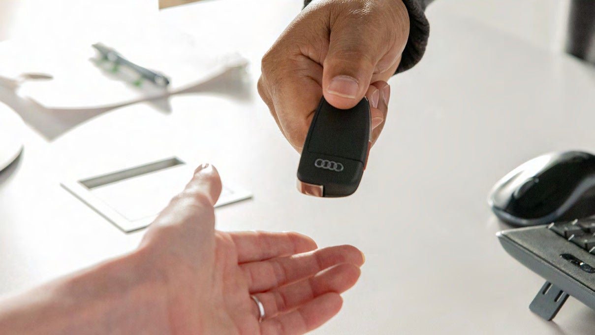 Audi key handed across the desk at delivery, when Audi Signature Care coverage begins