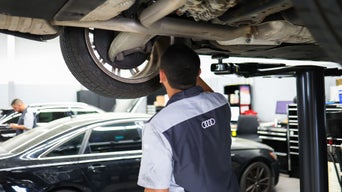 Service technician servicing vehicle.