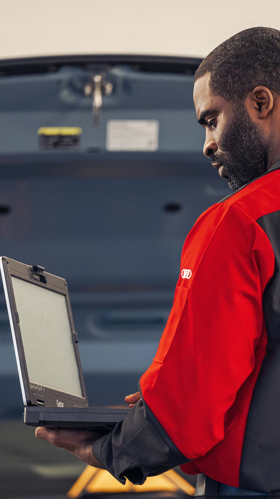 Audi service technician working on an Audi vehicle.