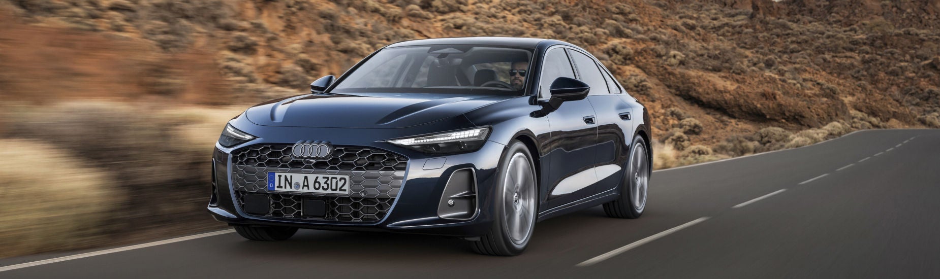 Blue Audi Sedan driving down the highway