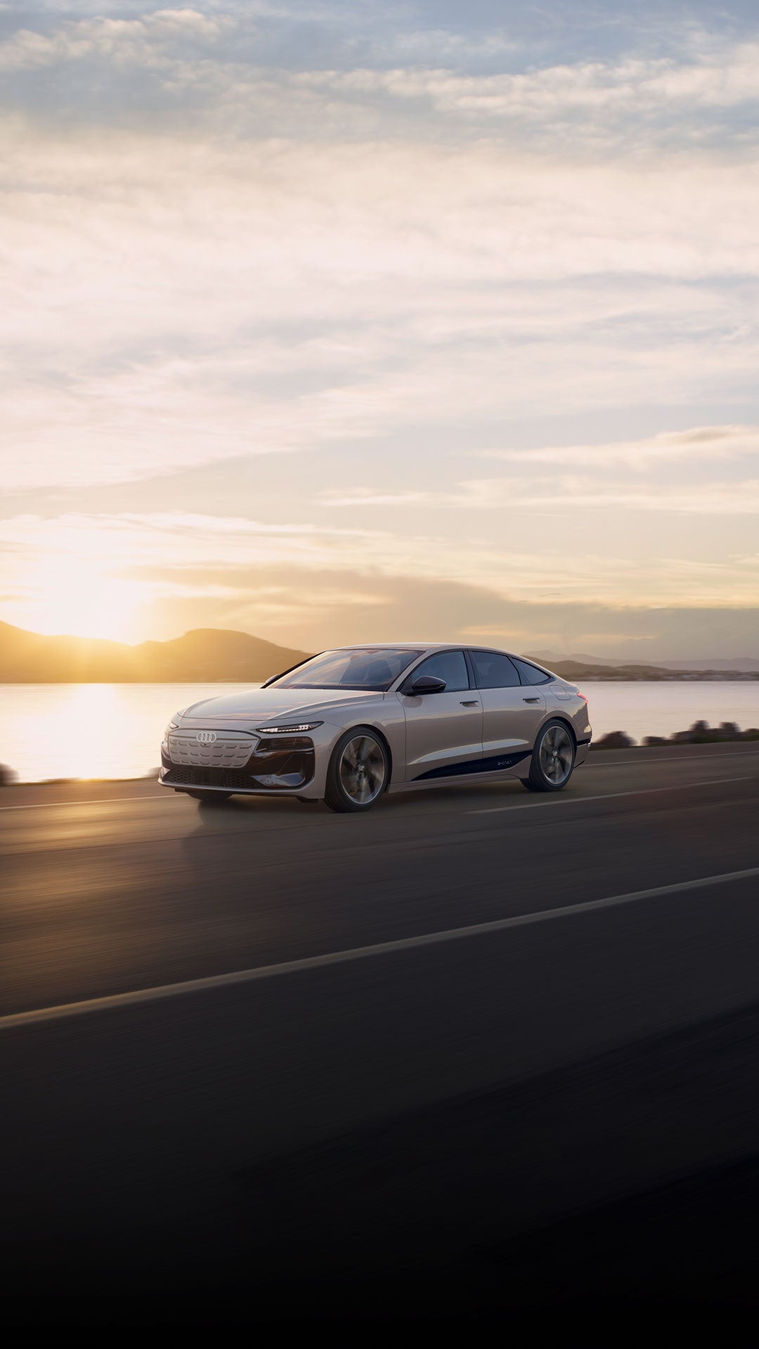 Three-quarter side view of a white Audi A6 e-tron parked in front of a modern home.