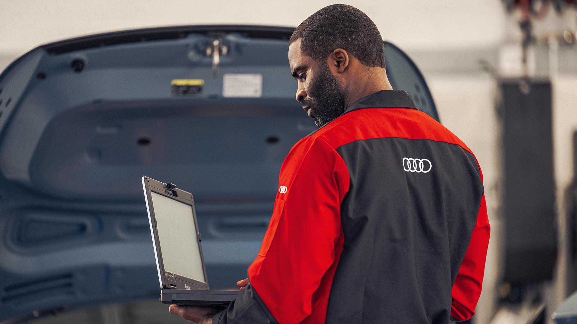 Audi service technician inspecting vehicle diagnostics