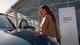 An Audi customer opening the driver's side door on an Audi vehicle.