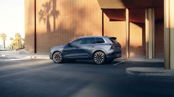 Side profile of the Audi Q7 parked by a modern building.