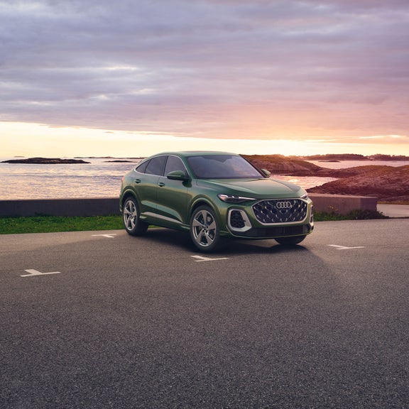 Three-quarter side view of the Audi Q5 parked by a waterfront.
