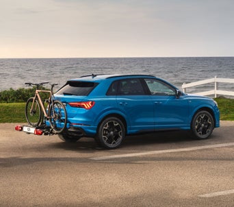Blue Audi Q3 with a bike rack and a bike