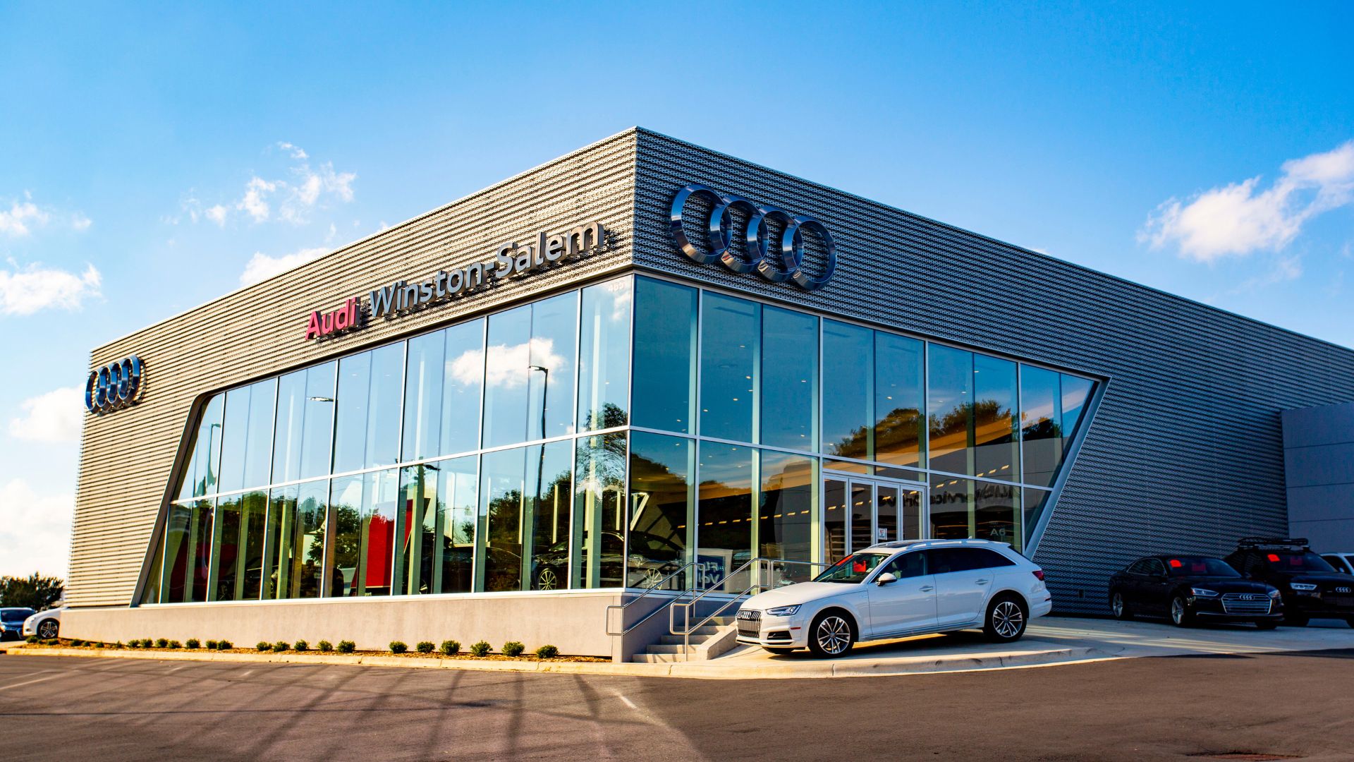 Audi Winston-Salem dealership building with a white Audi SUV parked in front