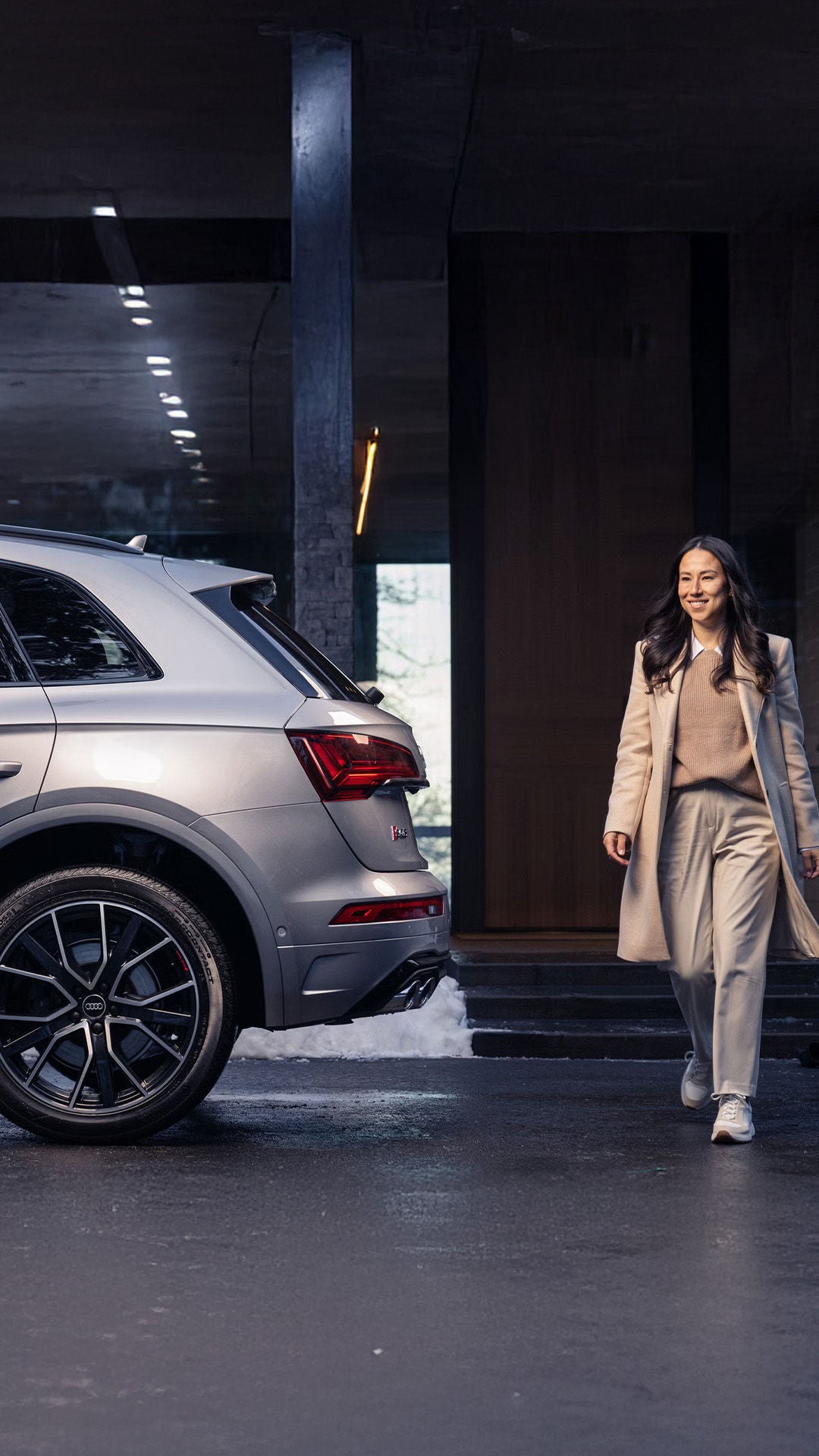 Stylish woman walking by an Audi SUV