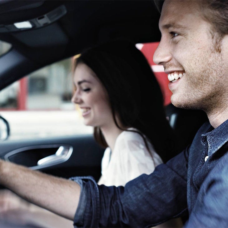 Two Audi customers driving in their leased Audi vehicle. 