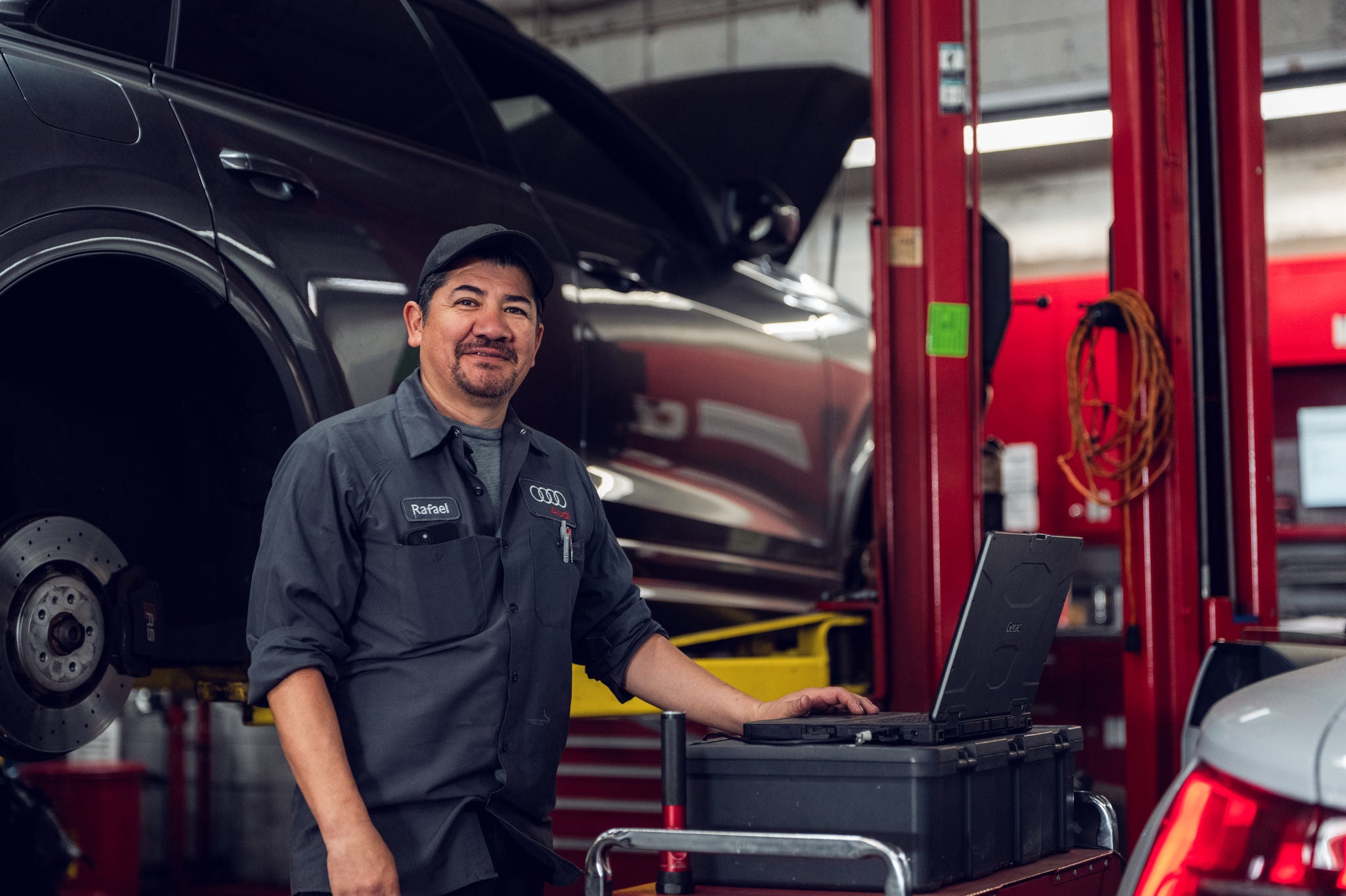Audi service technician servicing a vehicle.