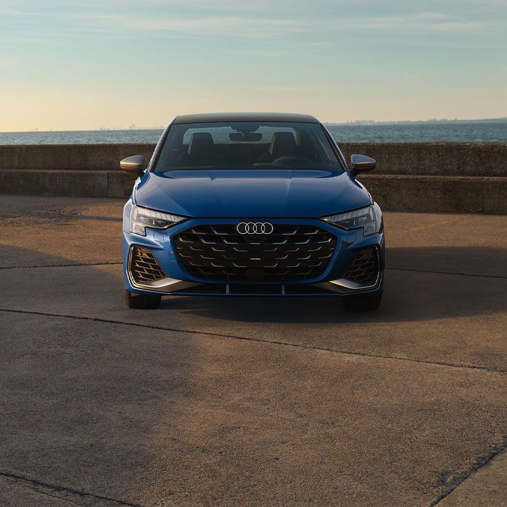 Profil avant d’une Audi S3 bleue garée.