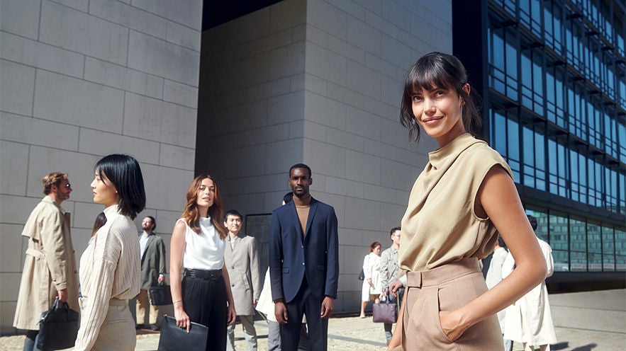 Group of people standing in front of a modern building.