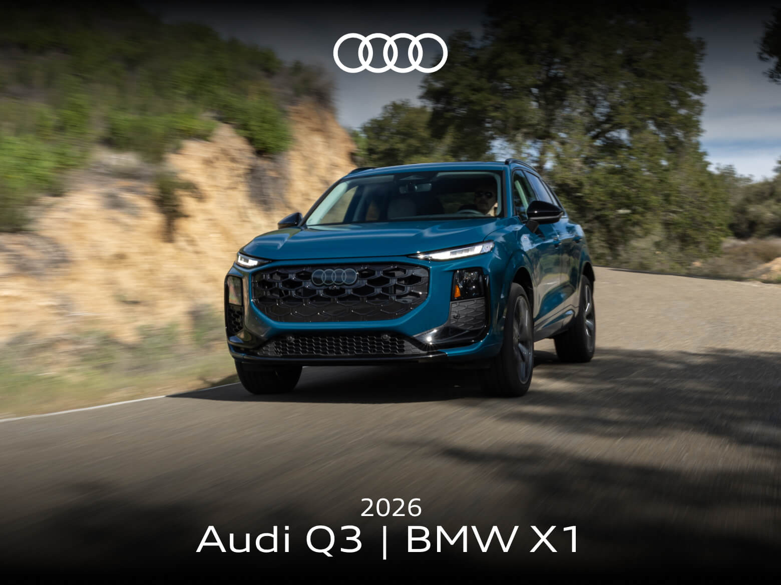 A blue Audi Q3 drives down a curvy tree-lined road.