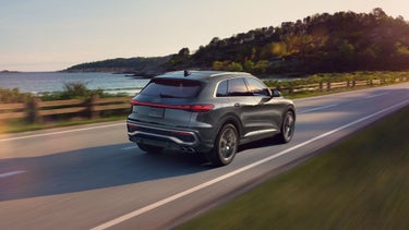 Rear aerial view of the Audi SQ5 accelerating in a country landscape.