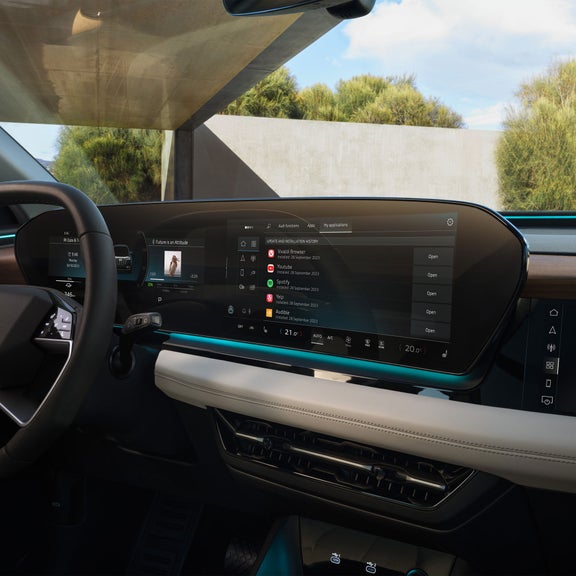 Interior view of the Audi Q6 e-tron dashboard including virtual cockpit, MMI touch display, and passenger side display.  