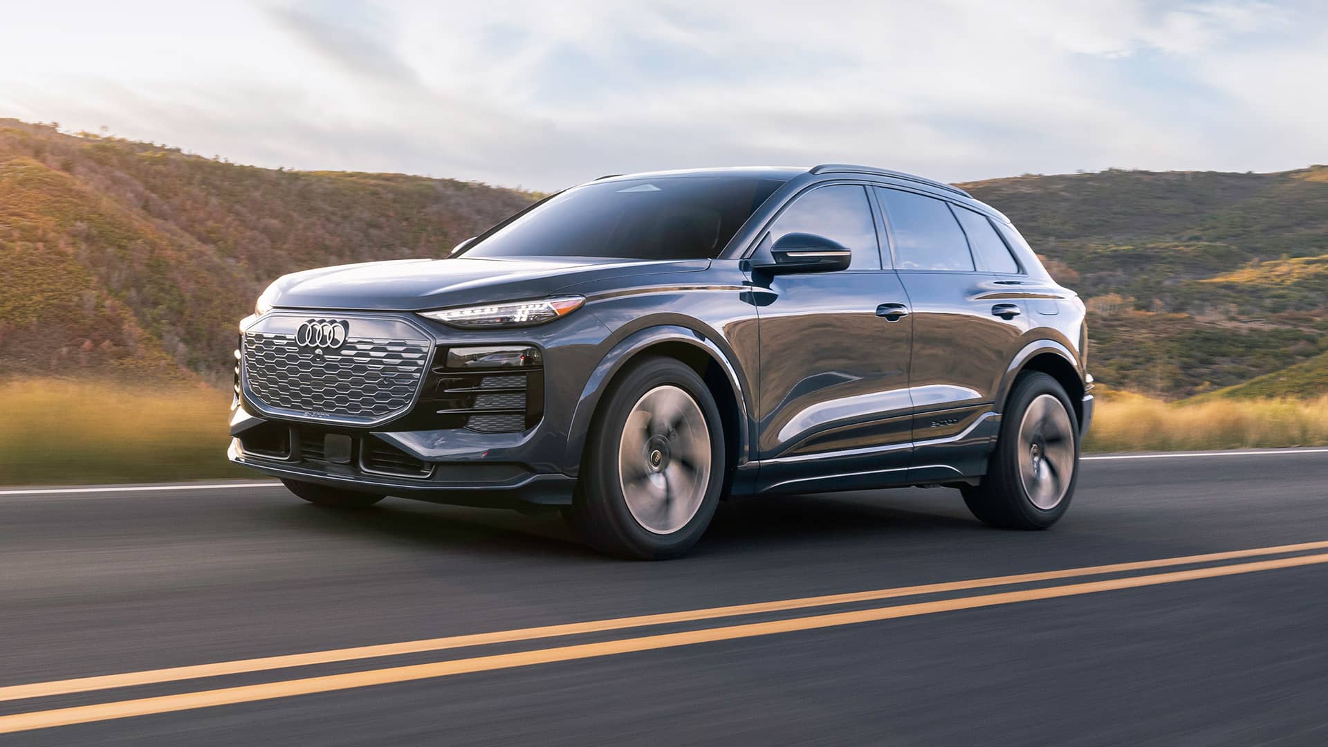 Side profile of an Audi Q6 e-tron, accelerating. 