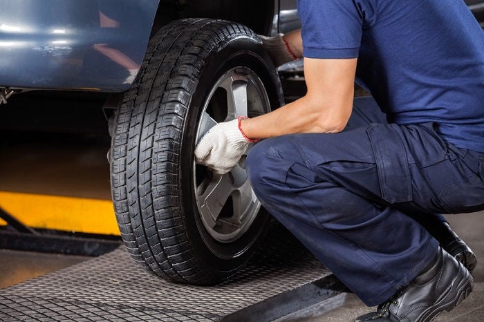 Audi tire service technician working on a wheel