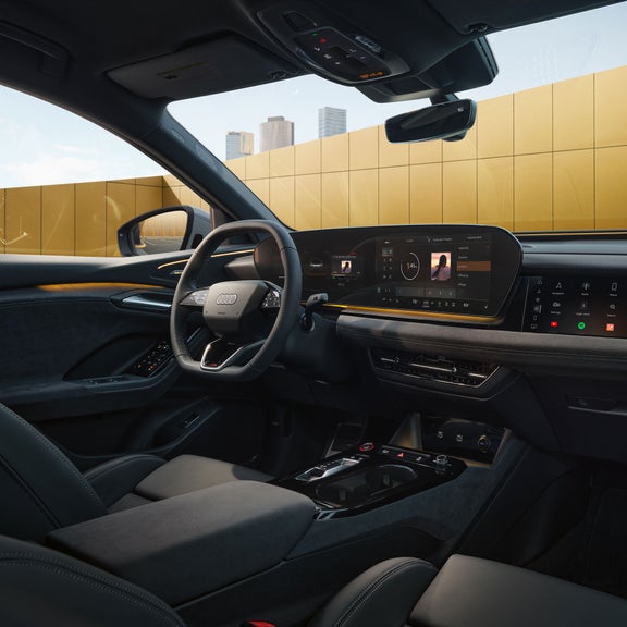 Gros plan sur le cockpit virtuel Audi et le volant de l'Audi SQ6 Sportback e-tron, illustrant la fonction de bande lumineuse d'interaction.