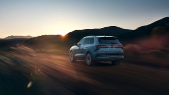 Rear profile of an Audi Q7 driving on the highway.