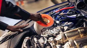 Service technician replacing engine filter.