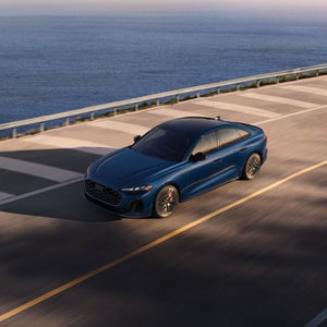 Aerial front view of the Audi S5 accelerating on an oceanside road.