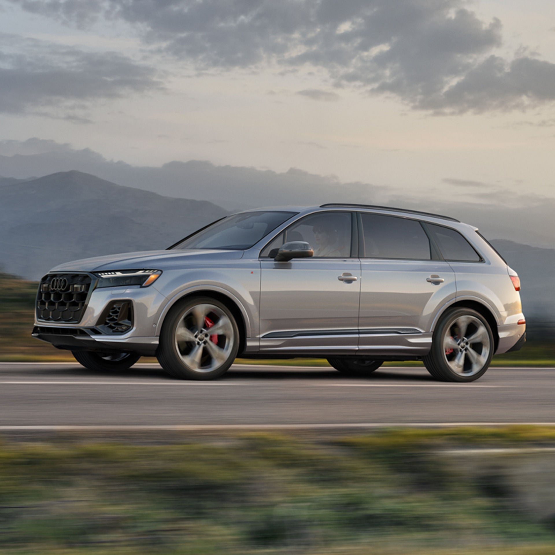 Left profile view of an Audi Q7 accelerating.