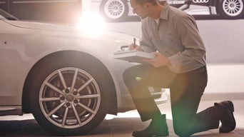 Service technician checking over Audi vehicle.
