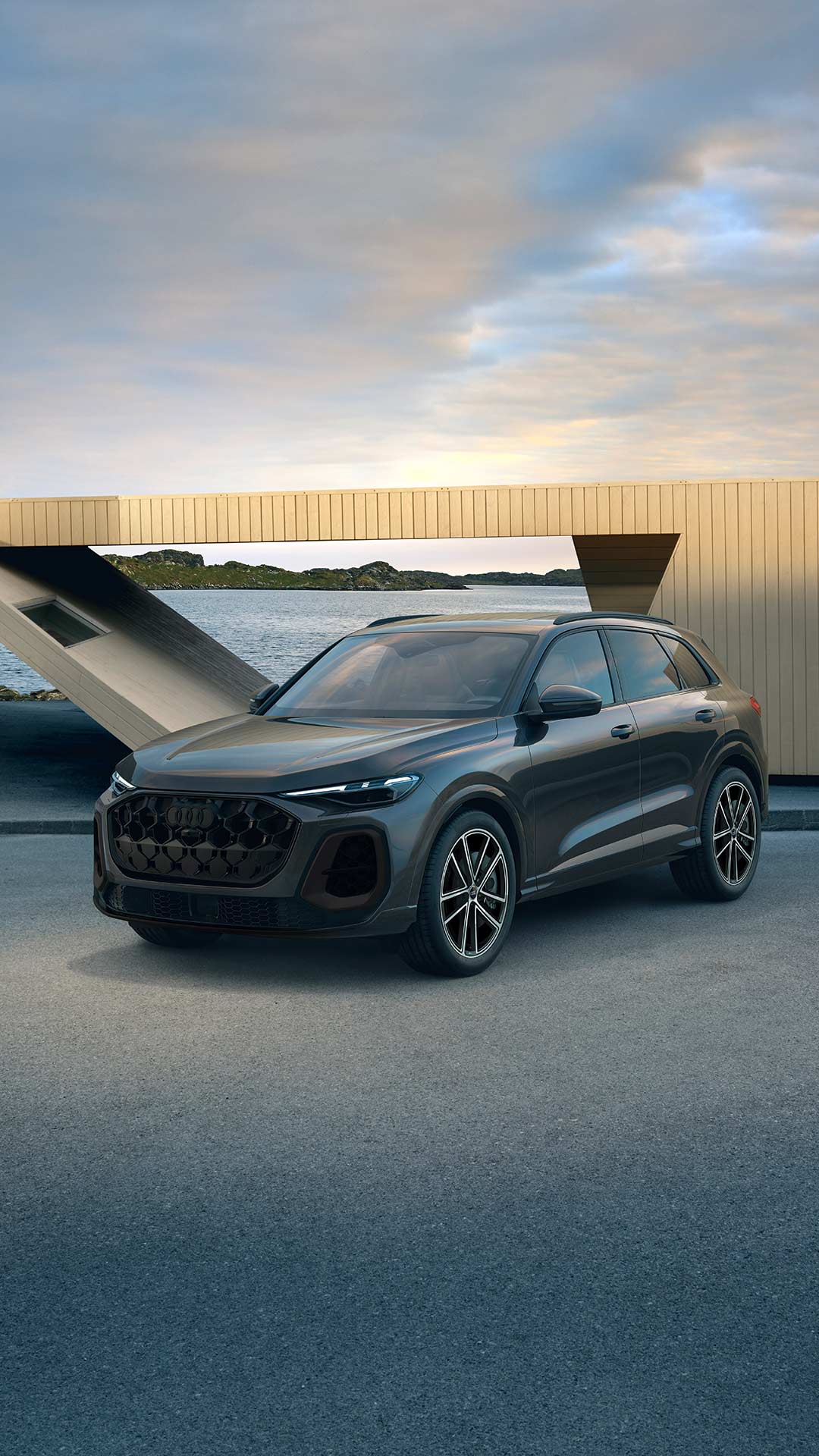 Femme se tenant debout, à gauche d’une Audi&nbsp;RS5 Sportback&nbsp;2023 de couleur gris espace.