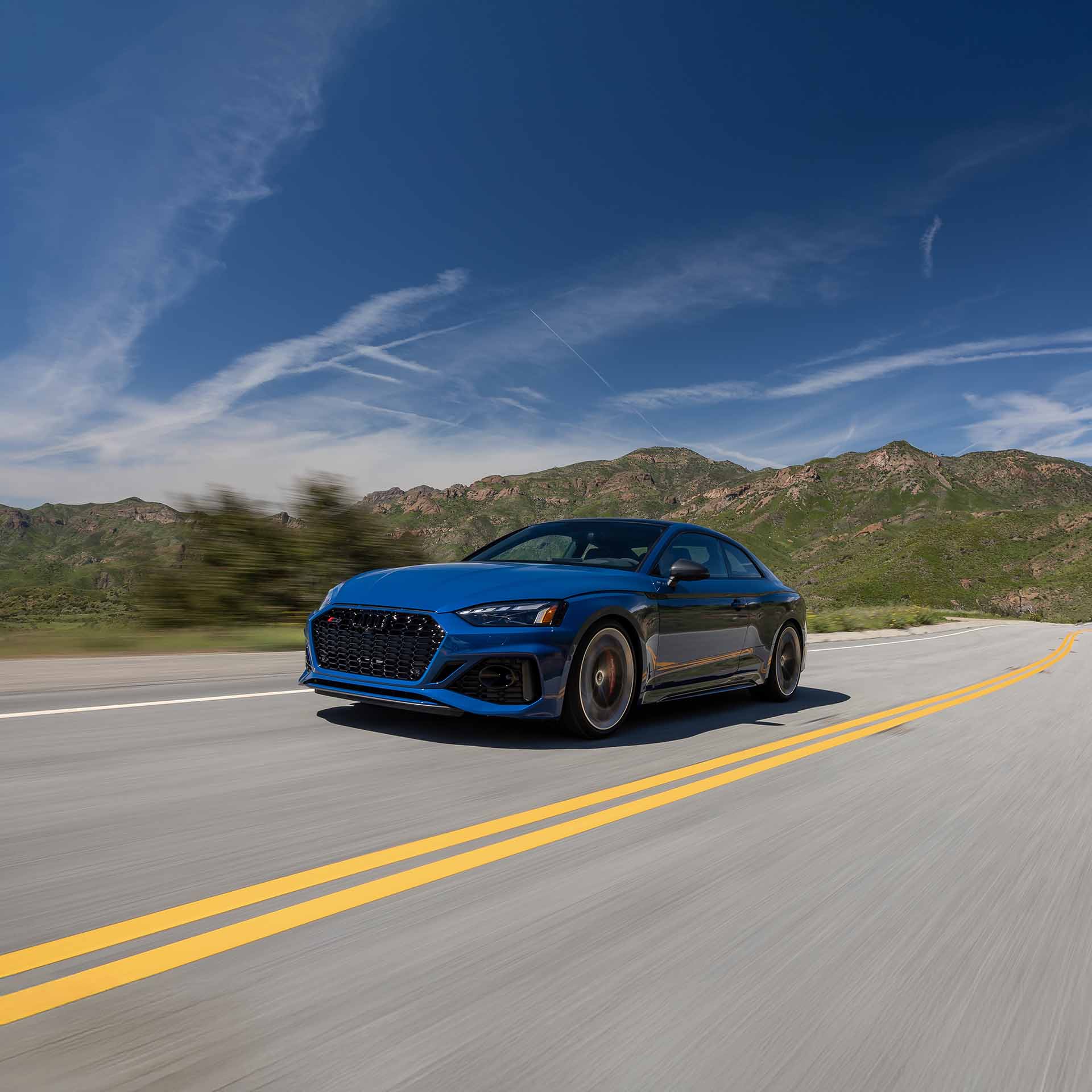 Three quarter profile view of an Audi accelerating.