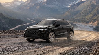 Front profile of an Audi Q8 accelerating.