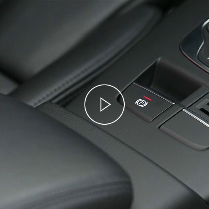 Close-up photo of the parking brake switch inside an Audi vehicle.