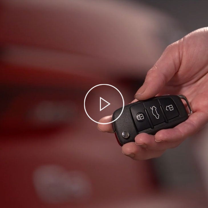  Close-up photo of the power tailgate button on the key to an Audi vehicle. 