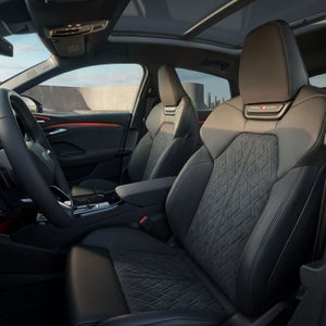 Interior view of the driver's cockpit in the Audi SQ6 Sportback e-tron, showing the front sport seats.