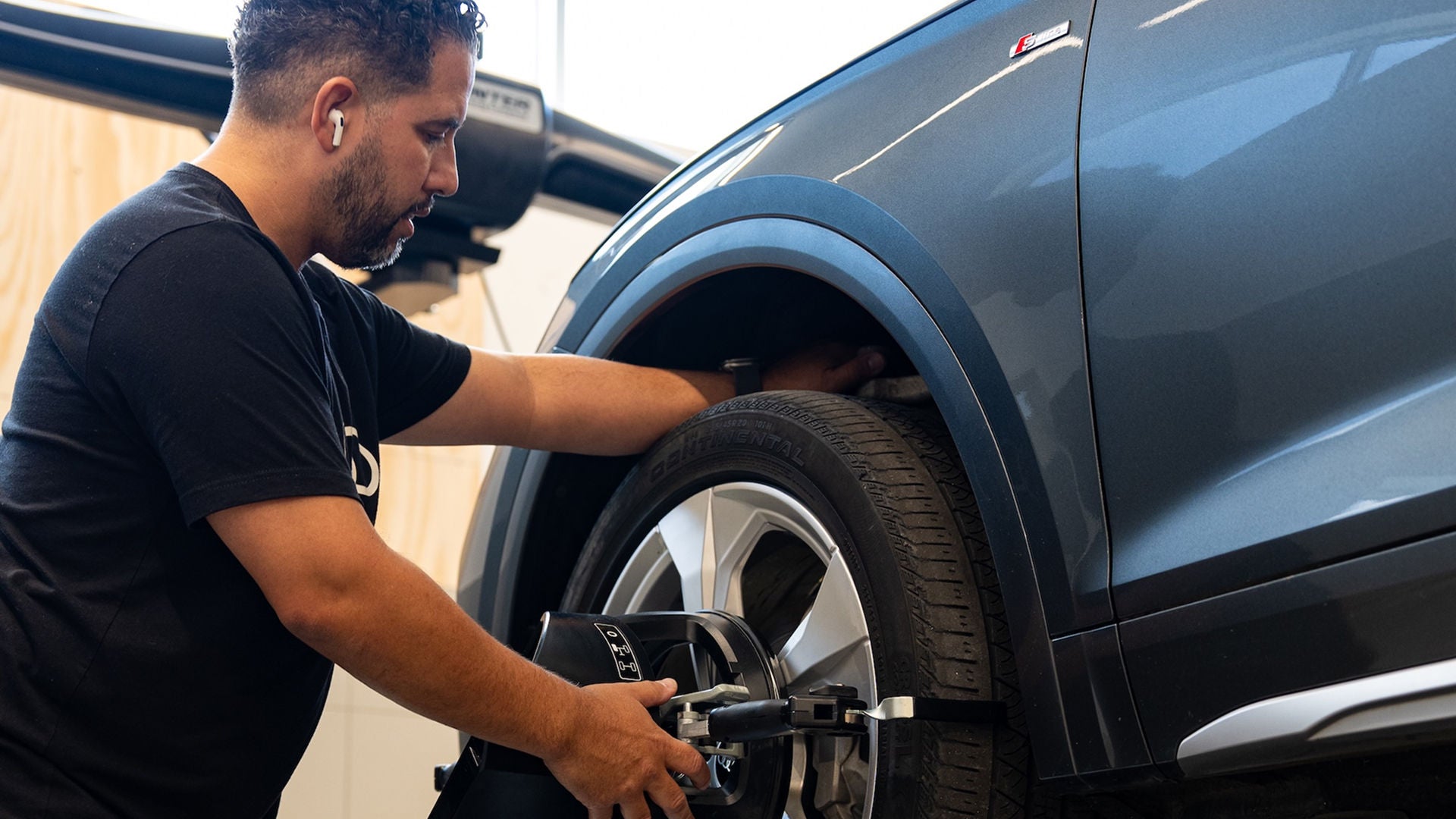 Audi service technician servicing a vehicle.
