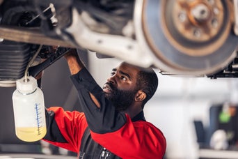 Service technician servicing vehicle. 