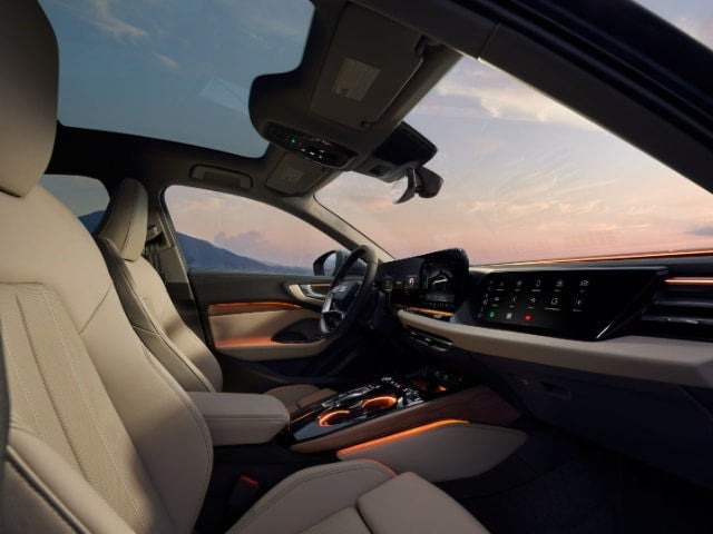 Close‑up of the Audi A5 interior highlighting the steering wheel, infotainment display