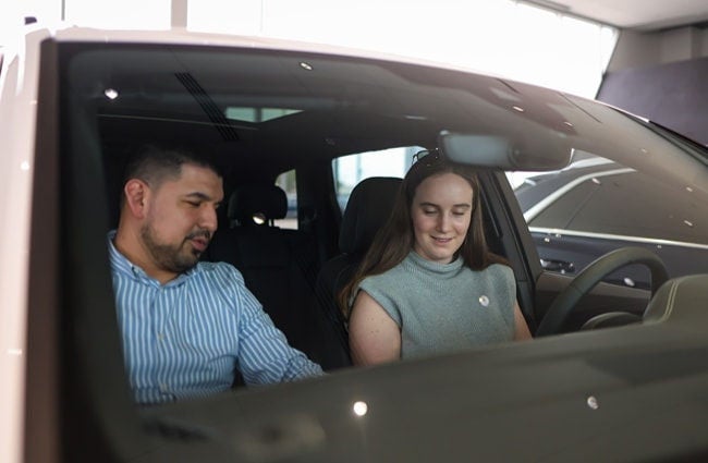 Salesperson assisting client inside an Audi vehicle