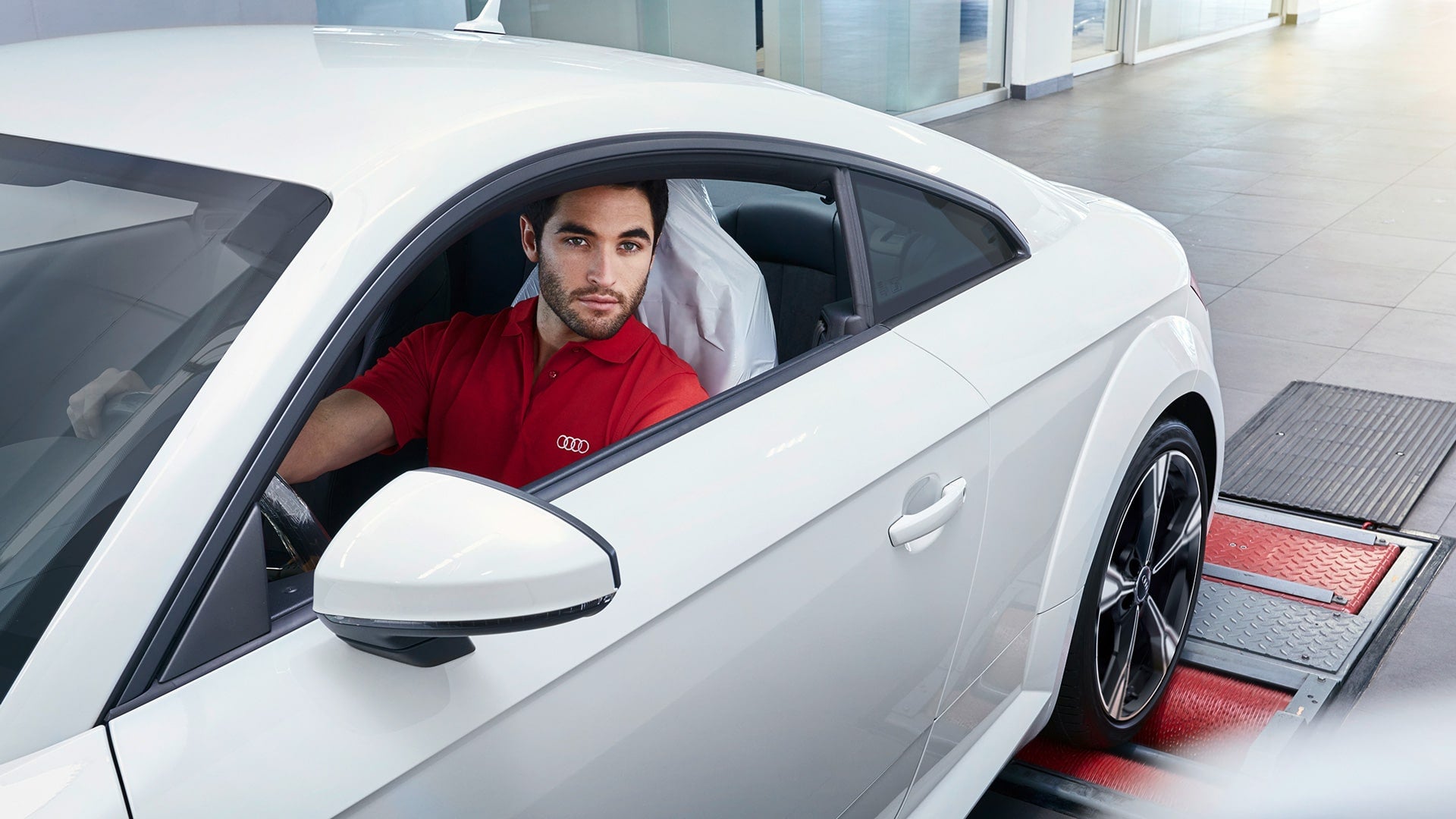 Un technicien Audi effectue l’entretien d’un véhicule Audi.